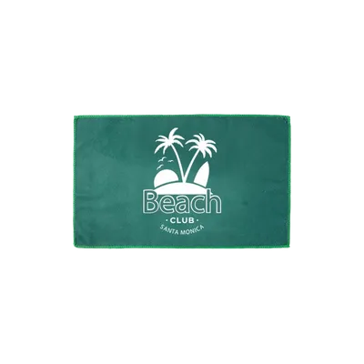 A folded custom beach towel with a personalized 'Beach Club Santa Monica' design featuring palm trees, promoting a premium brand quality.